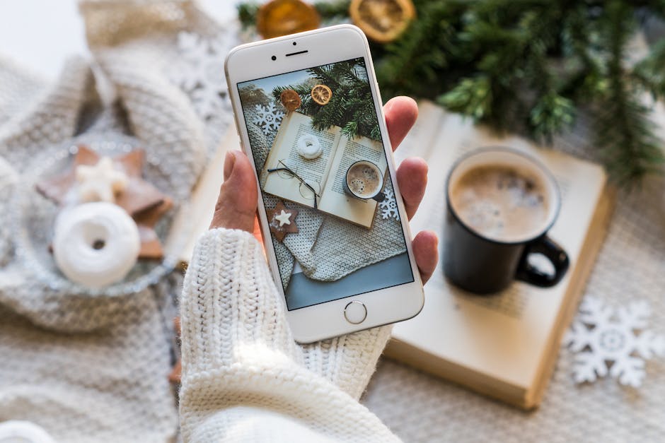 Top view of cozy winter setting with coffee, smartphone capturing a warm flat lay.