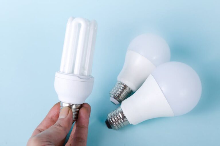 Close-up of energy-saving CFL and LED light bulbs on a blue background, showcasing eco-friendly lighting solutions.