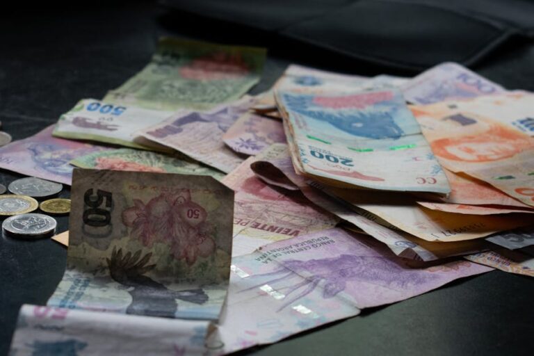 A mix of international banknotes and coins displayed on a table, highlighting diverse world currencies.